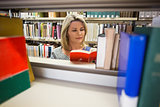 Mature student reading a book in library