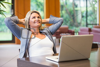 Blonde businesswoman smiling using laptop