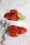 Dried tomatoes with basil leaves.