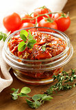 sun-dried tomatoes with herbs in a glass jar