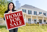 Woman Holding Home For Sale Sign in Front of House