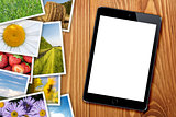 Tablet with blank screen and stack of printed pictures collage