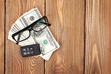Money cash, glasses and car remote key on wooden table