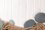 Wooden background with marine rope and sea stones