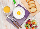 Healthy breakfast with fried egg, toasts and salad
