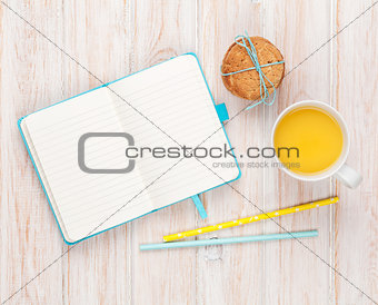 Cup of orange juice, gingerbread cookies and notepad