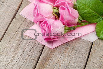 Garden pink roses bouquet over wooden table