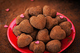 Heart shaped chocolate truffles on red plate