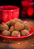 Heart shaped chocolate truffles on red plate