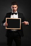 Young man holding a chalkboard