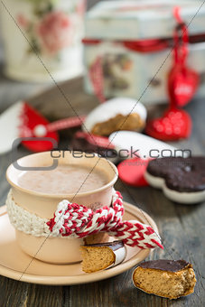  Cup of cocoa and gingerbread heart on wooden table.