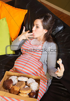 Donut Eating Pregnant Woman on Sofa