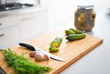 Closeup on cucumbers garlic and dill on cutting board