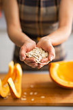 Closeup on young housewife showing pumpkin seeds
