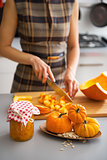 Closeup on young housewife cutting pumpkin for pickling