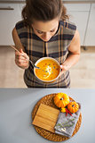 Closeup on young housewife eating pumpkin soup