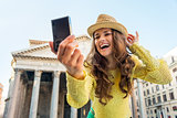 Happy young woman making selfie in front of pantheon in rome, it
