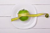 Green apple with measuring tape