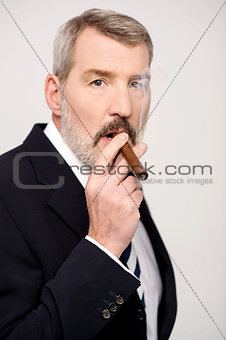 Aged man smoking cigar over white