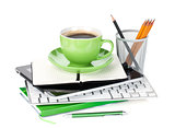 Green coffee cup on office supplies