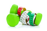 Two green dumbells and tape measure. Fitness and health