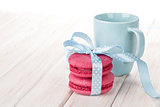 Red macarons with blue ribbon and milk cup