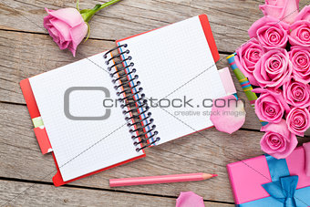 Blank notepad and gift box full of pink roses