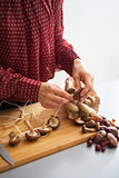 Closeup on young housewife stringing mushrooms on string