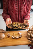 Closeup on young housewife showing dried mushrooms