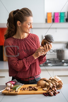 Young housewife holding jar of pickled mushrooms