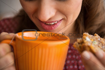 Closeup on young housewife drinking tea with freshly baked pumpk