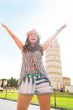 Happy young woman rejoicing in front of leaning tower of pisa, t