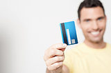 Handsome man holding debit card