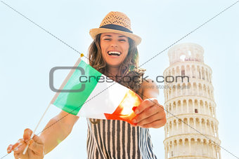 Happy young woman showing italian flag in front of leaning tower