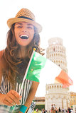Happy young woman showing italian flag in front of leaning tower