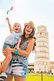 Happy mother and baby girl with italian flag in front of leaning