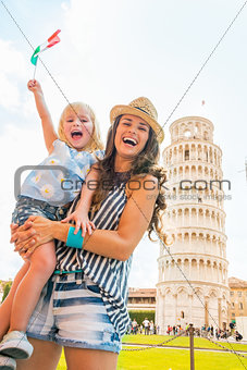 Happy mother and baby girl with italian flag in front of leaning