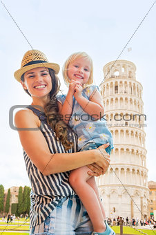 Portrait of happy mother and baby girl in front of leaning tower
