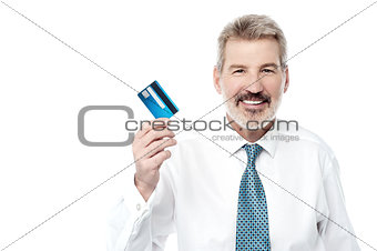 Smiling male executive showing debit card