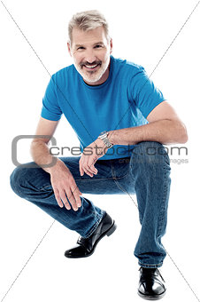 Handsome man crouching down and smiling