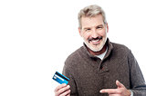 Smiling aged man showing his debit card