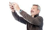 Happy aged man taking pictures of themselve
