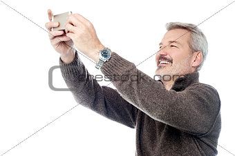 Happy aged man taking pictures of themselve