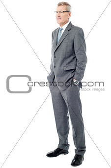 Experienced businessman with hands in pockets