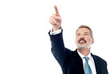 Happy businessman pointing at copyspace