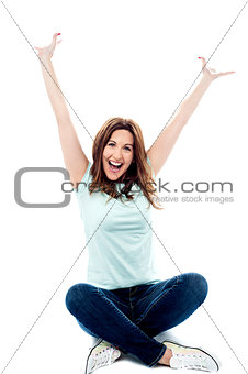 Woman with hands up sitting in crossed legs