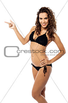Smiling bikini woman pointing her finger