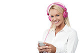 Smiling woman enjoying music with her mobile phone