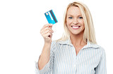 Smiling female model holding up credit card.