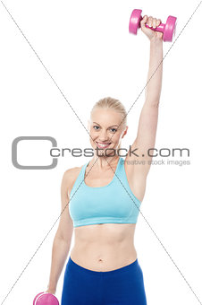 Young sporty woman holding dumbbells